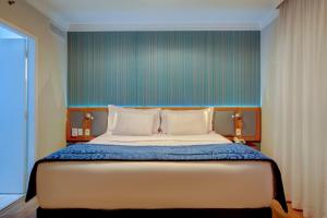 圣保罗Quality Suítes Oscar Freire的一间卧室设有一张蓝色墙壁的大床