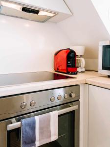 凯斯特海伊Diófa Apartman的厨房配有带红色用具的炉灶烤箱
