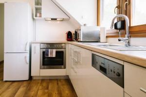 凯斯特海伊Diófa Apartman的白色的厨房配有水槽和冰箱