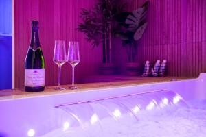 兰斯Art Déco Champagne & Spa的一瓶葡萄酒和两杯酒杯坐在柜台上