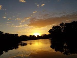 伯利兹城River Bend Resort Bze的日落在河流上,阳光照耀
