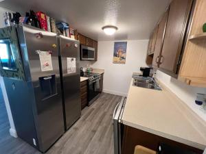 哥德伍德Rustic Girdwood Condo的厨房配有不锈钢冰箱和木制橱柜