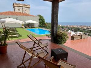 Sant’Agata Li Battiati Villa Leucatia的一个带两把椅子的庭院和一个游泳池