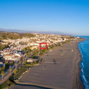 贝纳哈拉菲Casa 1ª linea de playa Benajarafe的海滩空中景色,带有红色标志