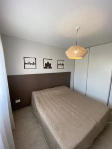里奥夸尔托Dptos equipados Gaudard的卧室配有一张床,墙上有三幅照片