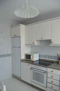 卡瓦尼亚斯Precioso apartamento de 3 habitaciones en Cabañas.的厨房配有白色橱柜和微波炉