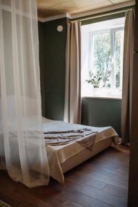 维尔扬迪Hubane korter Viljandi vanalinnas的窗户和窗帘的房间的一张床位