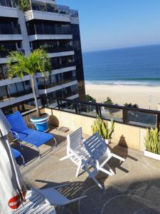 里约热内卢欧神诺科帕卡巴纳酒店的一个带椅子的阳台、海滩和大楼