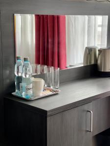 奥尔库什Apartamenty Centrum的配有两瓶水和一盘眼镜的柜台