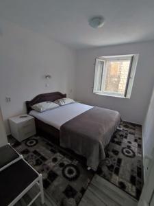 帕里斯特Apartment Rosić的一间卧室设有一张大床和一个窗户。