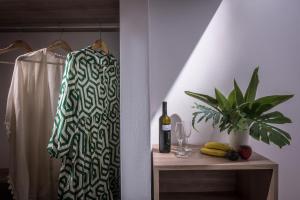 赫索尼索斯福拉瑞酒店的一瓶葡萄酒和一棵植物架上的毛巾
