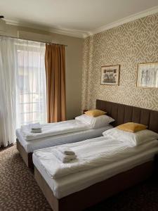 奥尔库什Apartamenty Centrum的酒店客房设有三张床和窗户。