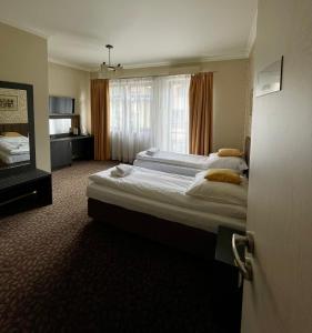 奥尔库什Apartamenty Centrum的酒店客房设有两张床和窗户。