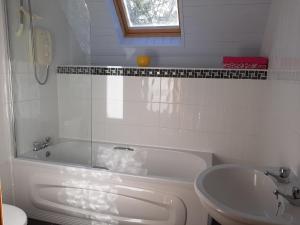 韦斯特波特Traditional Cosy Cottage with beautiful views的白色的浴室设有浴缸和水槽。
