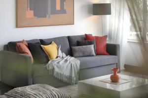 卡斯卡伊斯Cascais Sun Apartment的客厅配有带色彩缤纷枕头的灰色沙发