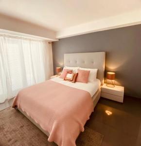卡斯卡伊斯Cascais Sun Apartment的卧室配有一张带粉红色枕头的大床