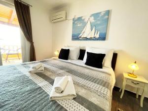 米利尼日落公寓的一间卧室配有一张大床,墙上挂着帆船画