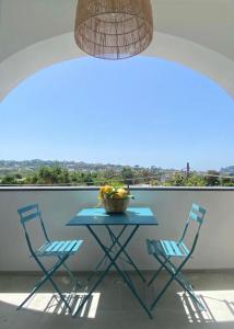 普罗奇达Teresa Madre的阳台上的桌子和两把椅子以及一碗水果