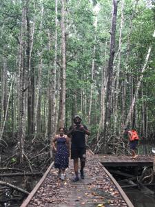 Pulau MansuarTABARI DIVE LODGE的木头上的桥梁上的男女