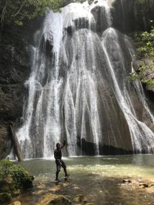 Pulau MansuarTABARI DIVE LODGE的站在瀑布前的水域上的人