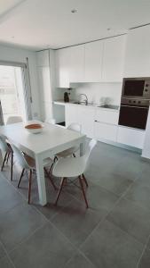 纳扎雷Brisa do Mar Ap.的白色的厨房配有白色的桌子和椅子