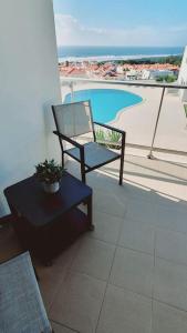 纳扎雷Brisa do Mar Ap.的阳台配有椅子,享有游泳池的景色