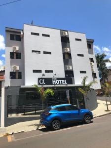 巴乌鲁Hotel Alfa de Bauru Ltda的停在酒店前的蓝色汽车