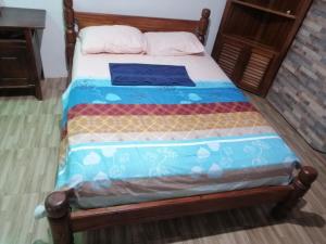 莱蒂西亚APARTA- Refugio El Retiro verde的一张带蓝色毯子的木框床