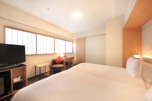 京都Richmond Hotel Premier Kyoto Ekimae的配有一张床和一台平面电视的酒店客房
