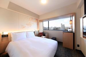 京都Richmond Hotel Premier Kyoto Ekimae的酒店客房设有一张白色大床和一个窗户。