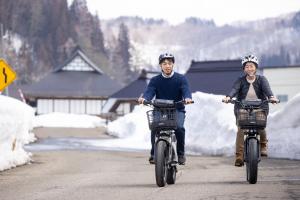 KobayashiMori no Bunkou Fuzawa - Vacation STAY 92943v的两个人骑着自行车沿着公路骑着头盔