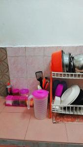 KodiangHOMESTAY UMI KODIANG的厨房柜台,配有餐具和盘子及餐具