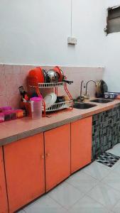 KodiangHOMESTAY UMI KODIANG的厨房柜台设有碗碟干燥架和水槽