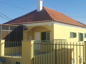 奥迪韦拉什Hostel Zabava的黄色的房子,上面有栅栏和十字架
