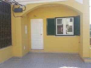 奥迪韦拉什Hostel Zabava的黄色的建筑,有白色的门和窗户