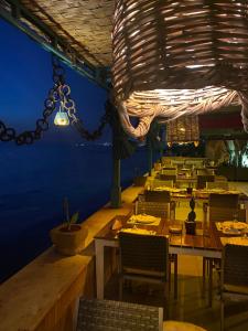 Ad DawwārahHalat sailing club Guest house的一间带桌椅和吊灯的用餐室