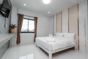 Ban Pho TaiGet Sleep @ท่าศาลา的一间白色卧室,配有床和电视