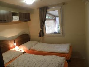 科兰Mobile homes Ante Mali的小房间设有两张床和窗户
