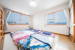 旭川GUESTHOUSE CHIYOGAOKA的一间带一张大床的卧室,位于带窗户的房间内