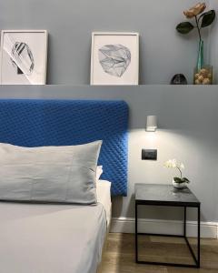 卡塔尼亚Calumidda的一间卧室配有一张带蓝色床头板的床和一张桌子