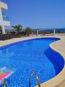 珊瑚湾3 Bedroom Seaview Villa direct in Coral Bay with Pool的一座大楼前带椅子的大型蓝色游泳池