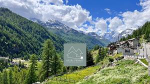 瓦尔格里森凯Hotel & Restaurant Perret - Mountain People的山 ⁇ 中房屋的标志