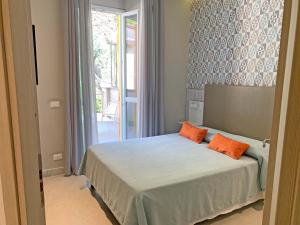 马纳罗拉卡迪安德烈酒店的一间卧室配有一张带两个橙色枕头的床