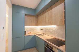 里斯本FLH Lapa Apartment with Interior Pateo的厨房配有蓝色橱柜和水槽