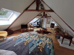 圣布里厄Aux Trois Palmiers的阁楼卧室配有一张带彩色毯子的床