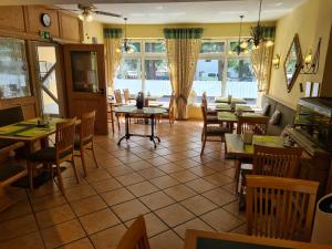 弗赖辛修道院花园酒店的餐厅设有桌椅和窗户。