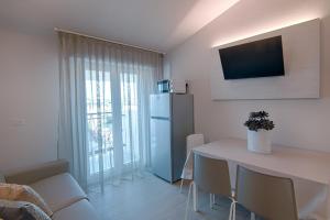 贝拉里亚-伊贾马里纳Villa Zavatta "B&B - Rooms & Apartments"的客厅配有桌子和冰箱