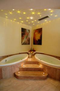 玛丽亚阿尔姆Hotel Edelweiss的一个带灯光的客房内的按摩浴缸