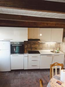 Donje Selo na ŠoltiHoliday Home - Pavenka的厨房配有白色橱柜、水槽和桌子