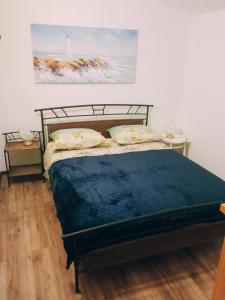 Donje Selo na ŠoltiHoliday Home - Pavenka的卧室配有一张床,墙上挂有绘画作品